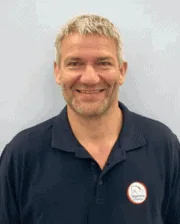 Dr. Palle Brink smiling, wearing a navy polo shirt with the Jägersro Hästklinik logo.