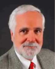 Professional headshot of Dr. Jack Easley wearing a gray checkered suit, white shirt, and red tie against a dark background.
