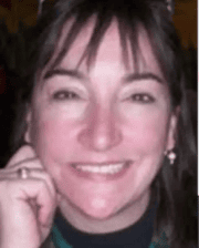 Portrait of Dr. Lynn Caldwell smiling, wearing earrings and a dark top.