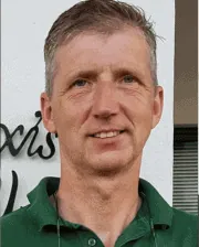 A man in a green polo shirt and tie.
